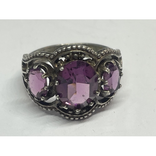 536 - A SILVER RING WITH AMETHYST COLOURED STONES