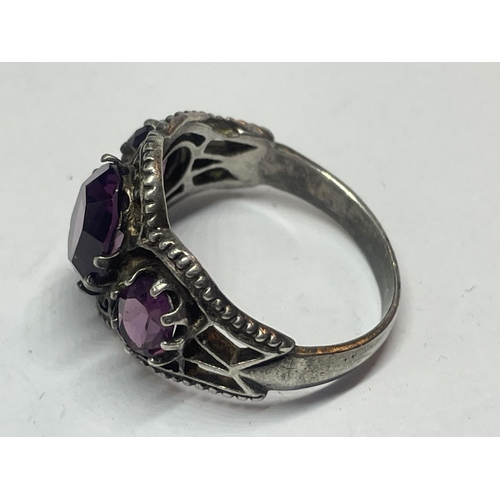 536 - A SILVER RING WITH AMETHYST COLOURED STONES