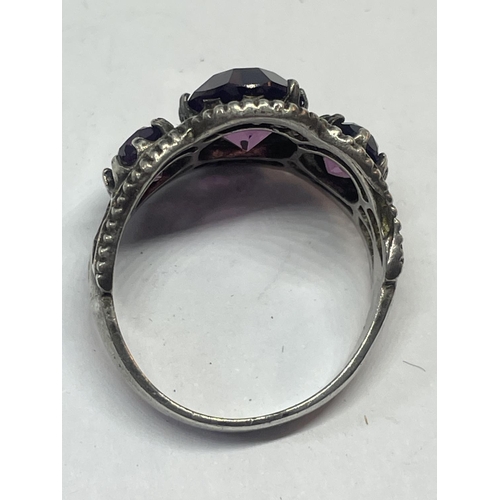 536 - A SILVER RING WITH AMETHYST COLOURED STONES