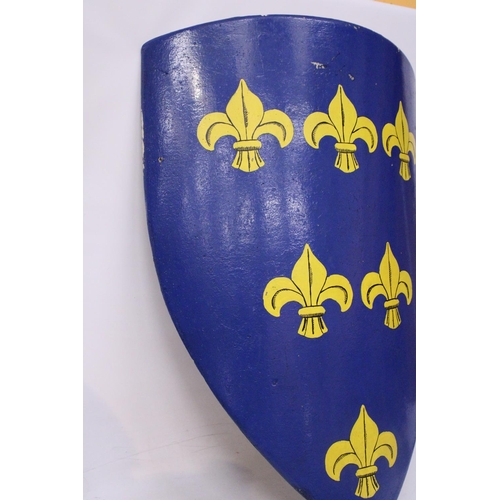 453 - A LARGE VINTAGE HAND PAINTED WALL SHIELD, HEIGHT 106CM. THE SHIELD WITH BLUE BACKGROUND WITH SIX FLE... 