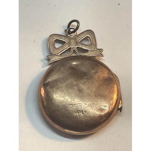 501 - A 9 CARAT GOLD (INDISTINCT HALLMARK) LOCKET WITH BOW DESIGN TO INCLUDE VINTAGE PHOTOGRAPHS GROSS WEI... 