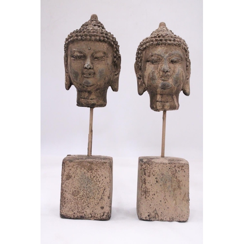 125 - A PAIR OF STONE BUDDHA HEADS ON STANDS