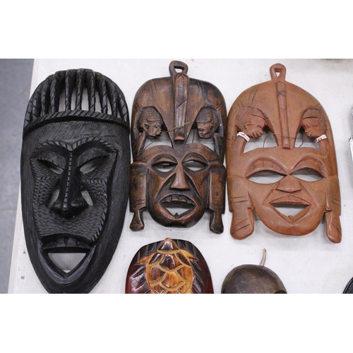 132 - FIVE AFRICAN HAND CARVED WOODEN MASKS - PLUS TWO SPEARS