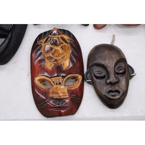 132 - FIVE AFRICAN HAND CARVED WOODEN MASKS - PLUS TWO SPEARS