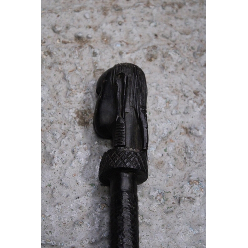 170 - AN ETHNIC AFRICAN BLACK WOODEN SPEAR - WITH CARVED HEAD DECORATION TO THE TOP