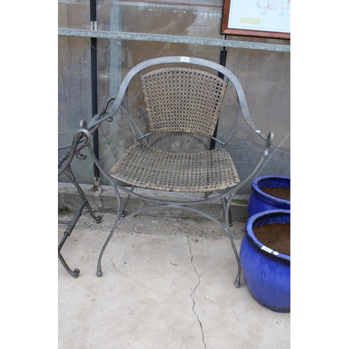 1514 - A METAL GARDEN CHAIR WITH RATTAN SEAT AND BACK AND A SIMILAR HEAVY METAL BENCH