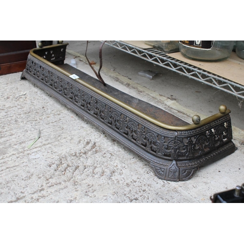 1604 - A VINATGE AND HEAVILY ORNATE CAST IRON FIRE FENDER WITH BRASS TRIM