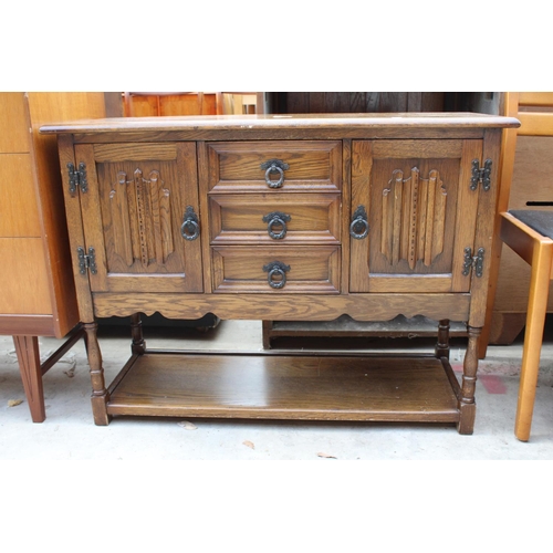 2541 - AN OAK JACOBEAN STYLE SIDE CABINET ENCLOSING 3 DRAWERS AND 2 CUPBOARDS WITH POT BOARD TO BASE ON TUR... 