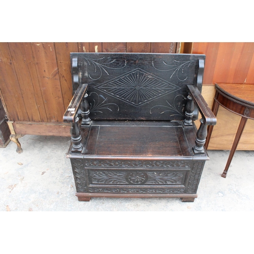 2801 - AN EARLY 20TH CENTURY OAK MONKS BENCH WITH CARVED PANELS