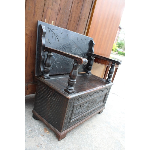 2801 - AN EARLY 20TH CENTURY OAK MONKS BENCH WITH CARVED PANELS