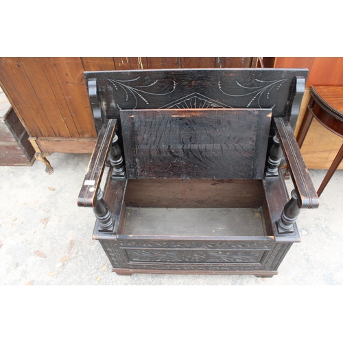 2801 - AN EARLY 20TH CENTURY OAK MONKS BENCH WITH CARVED PANELS