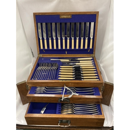 15 - A CASED CANTEEN OF CUTLERY WITH LIFT UP TOP CONTAINING KNIVES, FORKS AND CARVING EQUIPMENT, A DRAWER... 