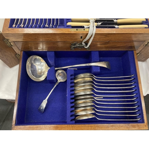 15 - A CASED CANTEEN OF CUTLERY WITH LIFT UP TOP CONTAINING KNIVES, FORKS AND CARVING EQUIPMENT, A DRAWER... 