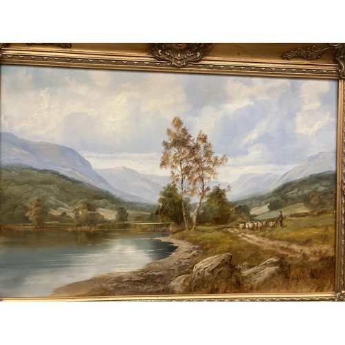 88 - A GILT FRAMED OIL ON CANVAS OF A LAKE SCENE WITH A FARMER MOVING STOCK SIGNED JACK R MOULD TO LOWER ... 