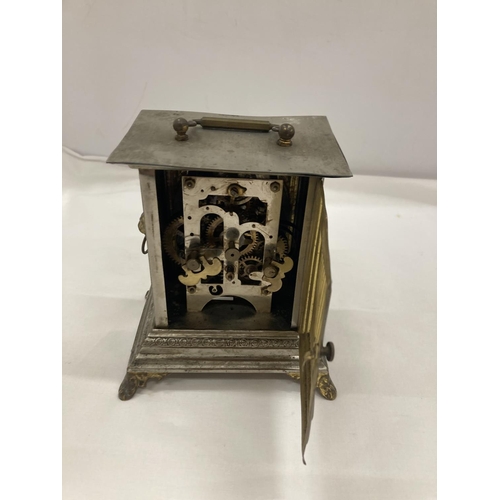 9 - AN OFFICER'S ALARM CLOCK WITH BRASS DECORATION AND LION HEADS TO THE SIDE