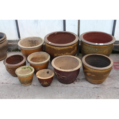 1653 - AN ASSORTMENT OF VARIOUS SIZED BROWN GLAZED GARDEN POTS, SOME DEPICTING DRAGONS