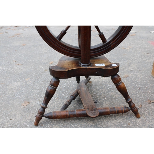 2877 - A BEECH FRAMED SPINNING WHEEL ON TURNED LEGS AND STRETCHERS