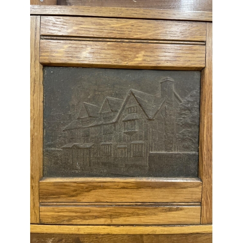 74 - AN EDWARDIAN OAK SMOKERS CABINET DEPICTING WILLIAM SHAKESPEARE WITH THREE SECTIONS. RIGHT HAND DOOR ... 