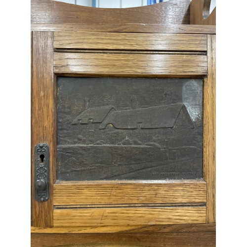 74 - AN EDWARDIAN OAK SMOKERS CABINET DEPICTING WILLIAM SHAKESPEARE WITH THREE SECTIONS. RIGHT HAND DOOR ... 