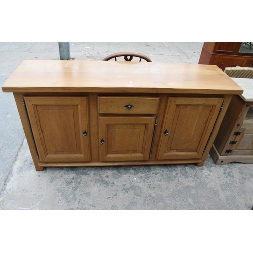 2905 - A MODERN OAK SIDEBOARD ENCLOSING THREE PANELLED DOORS AND SINGLE DRAWER, 68