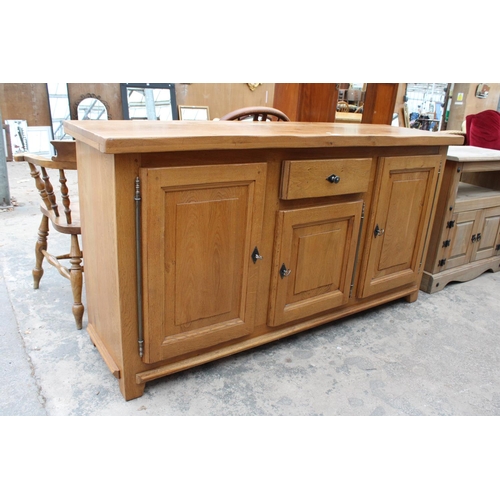 2905 - A MODERN OAK SIDEBOARD ENCLOSING THREE PANELLED DOORS AND SINGLE DRAWER, 68