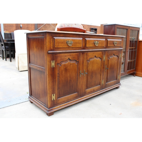 2949 - AN OAK GEORGE III STYLE DRESSER BASE, ENCLOSING 3 DRAWERS AND 3 PANELLED CUPBOARDS, WITH 'H' BRASS H... 