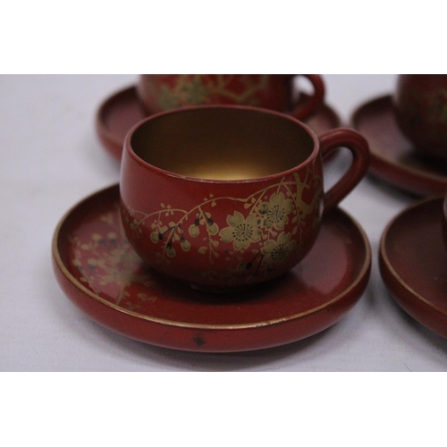 360 - A VINTAGE SET OF CHINESE GILT AND RED LACQUERED DESIGN TEA CUPS AND SAUCERS