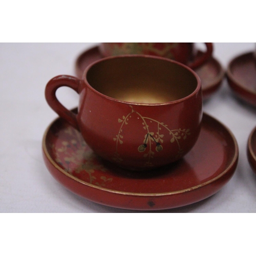 360 - A VINTAGE SET OF CHINESE GILT AND RED LACQUERED DESIGN TEA CUPS AND SAUCERS