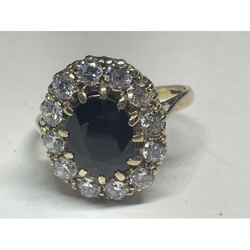 619 - A 9 CARAT GOLD DRESS RING WITH CENTRE BLUE STONE SURROUNDED BY CUBIC ZIRCONIAS SIZE Q IN A PRESENTAT... 