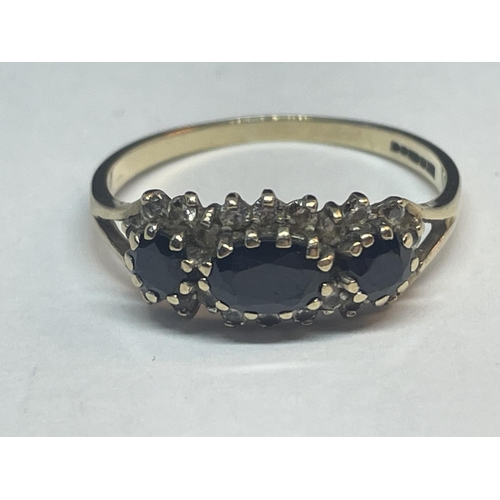 652 - A 9 CARAT GOLD RING WITH THREE IN LINE SAPPHIRES SURROUNDED BY CUBIC ZIRCONIAS SIZE Q