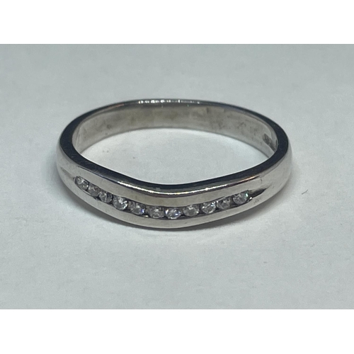 653 - A 9 CARAT WHITE GOLD RING WITH A LINE OF DIAMONDS IN A WISHBONE DESIGN SIZE K