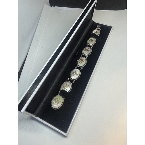 663 - AN ORIENTAL SILVER AND MOTHER OF PEARL CHARACTER LINK BRACELET IN A PRESENTATION BOX