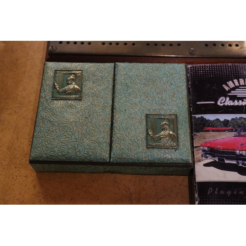 931 - A BRASS CRIB BOARD AND THREE PACKS OF VINTAGE CARDS