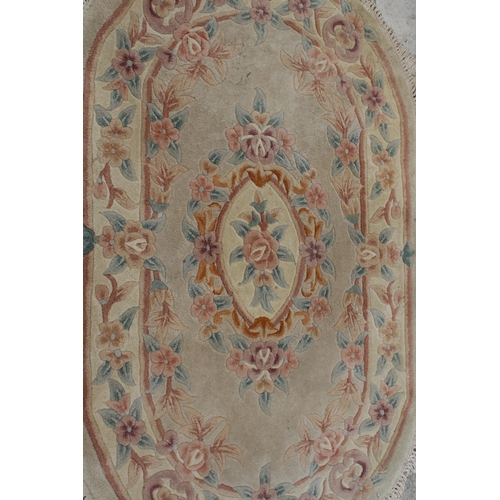 2492 - AN OVAL PEACH PATTERNED FRINGED RUG