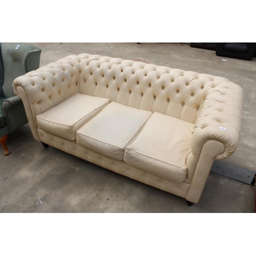 2863 - A MODERN CREAM FAUX LEATHER CHESTERFIELD THREE SEATER SETTEE