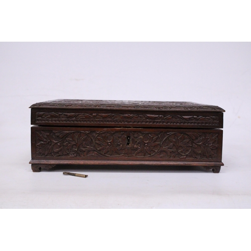 394 - AN ANGLO INDIAN HEAVILY CARVED BOX WITH KEY