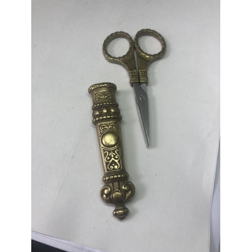 475 - A PAIR OF DECORATIVE BRASS DRESS MAKING SCISSORS AND A NEEDLE CASE