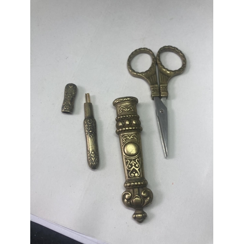 475 - A PAIR OF DECORATIVE BRASS DRESS MAKING SCISSORS AND A NEEDLE CASE