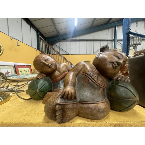 70 - TWO LARGE CARVED HARDWOOD ORIENTAL FIGURES OF A SLEEPING BOY AND GIRL APPROXIMATELY 22CM TALL