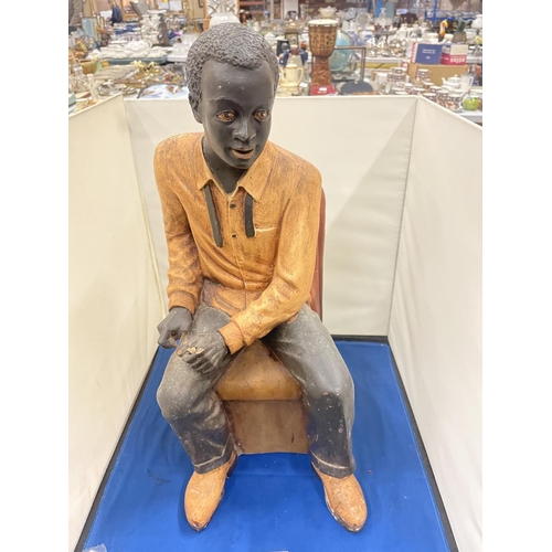 76 - A LARG FIGURE OF A MAN SITTING IN A CHAIR