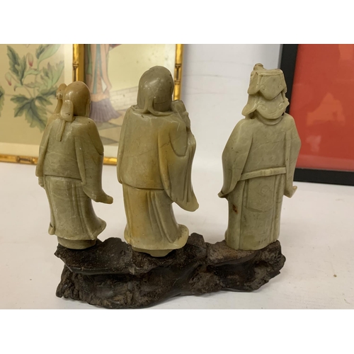 435 - A FINE CHINESE CARVED SOAPSTONE FIGURE GROUP OF THREE IMMORTALS MOUNTED ON A CARVED STAND