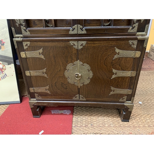 440 - A KOREAN WOOD AND BRASS APOTHECARY CABINET, REVEALING 14 DRAWERS, STACKED ON A HINGED DOOR COMPARTME... 