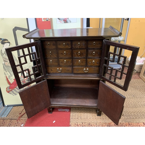 440 - A KOREAN WOOD AND BRASS APOTHECARY CABINET, REVEALING 14 DRAWERS, STACKED ON A HINGED DOOR COMPARTME... 