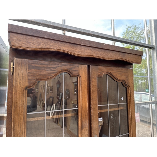 3064 - AN OAK CABINET WITH GLAZED AND LEADED UPPER PORTION, 37