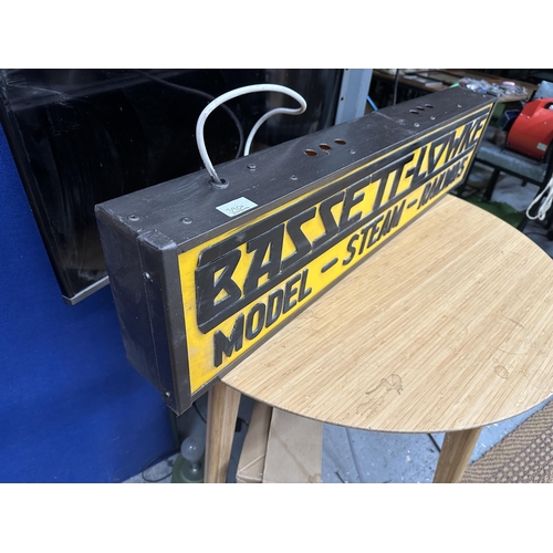 390A - AN ILLUMINATED BASSETT-LOWKE MODEL STEAM RAILWAYS SIGN (L:97CM H:22CM)