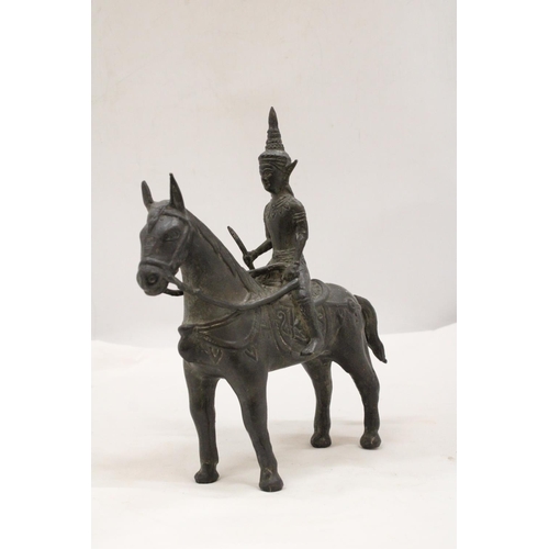 142 - AN ORIENTAL BRONZE HORSE AND WARRIOR RIDER, HEIGHT 25CM, LENGTH 23CM