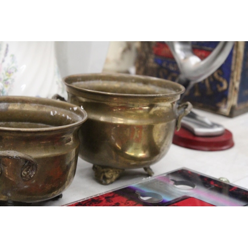 216 - THREE GRADUATED BRASS FOOTED AND HANDLED POTS