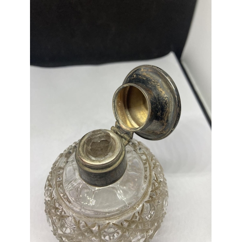 97 - A CUT GLASS BOTTLE WITH A HALLMARKED BIRMINGHAM SILVER TOP