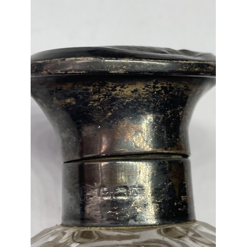 97 - A CUT GLASS BOTTLE WITH A HALLMARKED BIRMINGHAM SILVER TOP