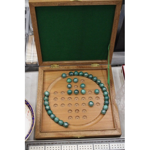 245 - A BOXED WOODEN SOLITAIRE BOARD WITH MARBLES PLUS A VINTAGE CRIBBAGE BOARD